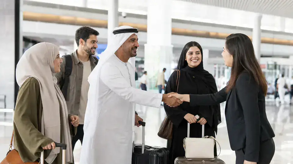 UAE travelers meeting a coordinator in a Chinese airport arrivals hall